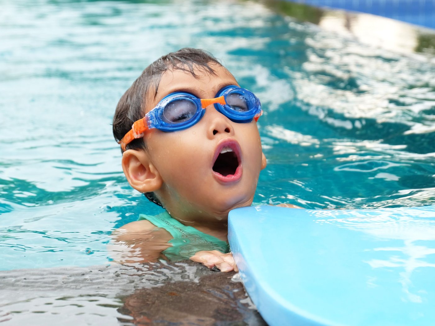 Kid swimming with a kickboard in a clean pool