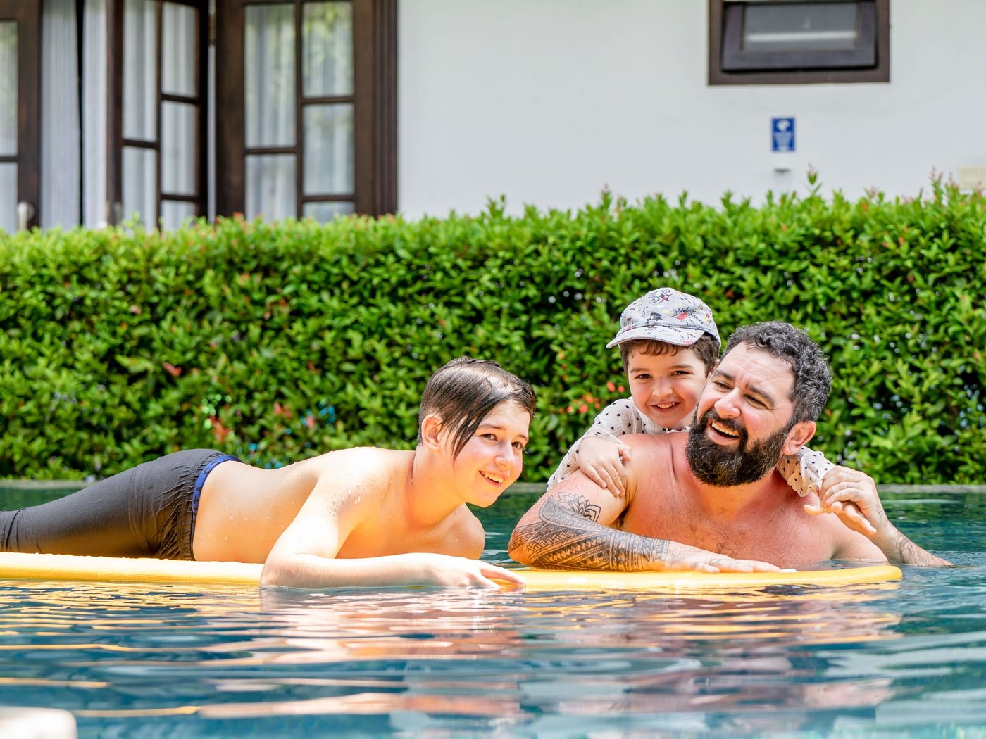 Family relaxing together in a backyard pool